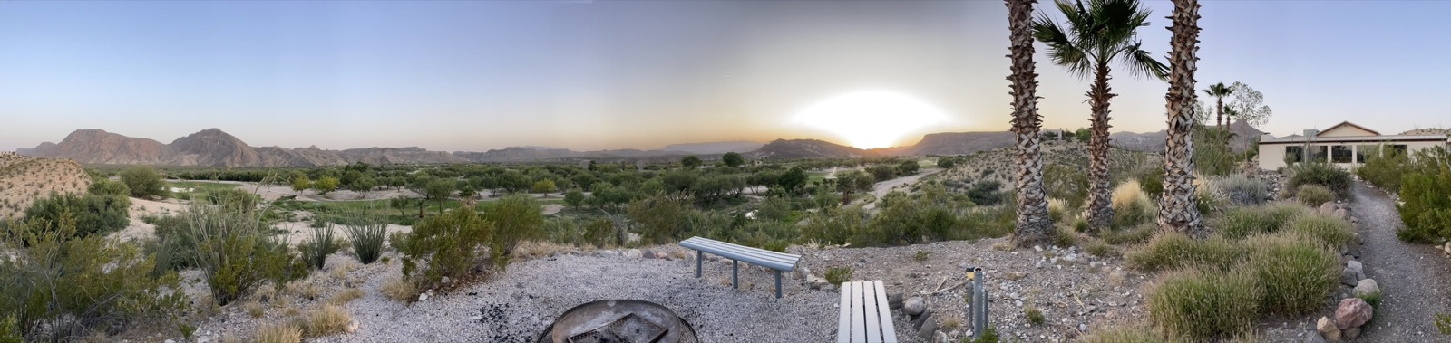 Desert sunset panorama over a golf course and mountains